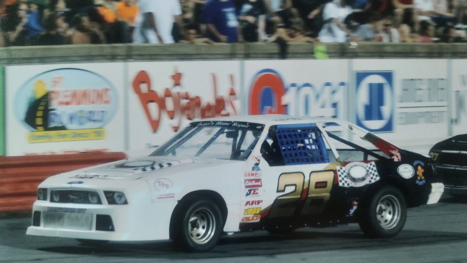 The #28 Mustang racing past a packed grandstand at Bowman Gray Stadium