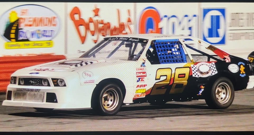 The #28 Mustang along the wall in front of track sponsor boards